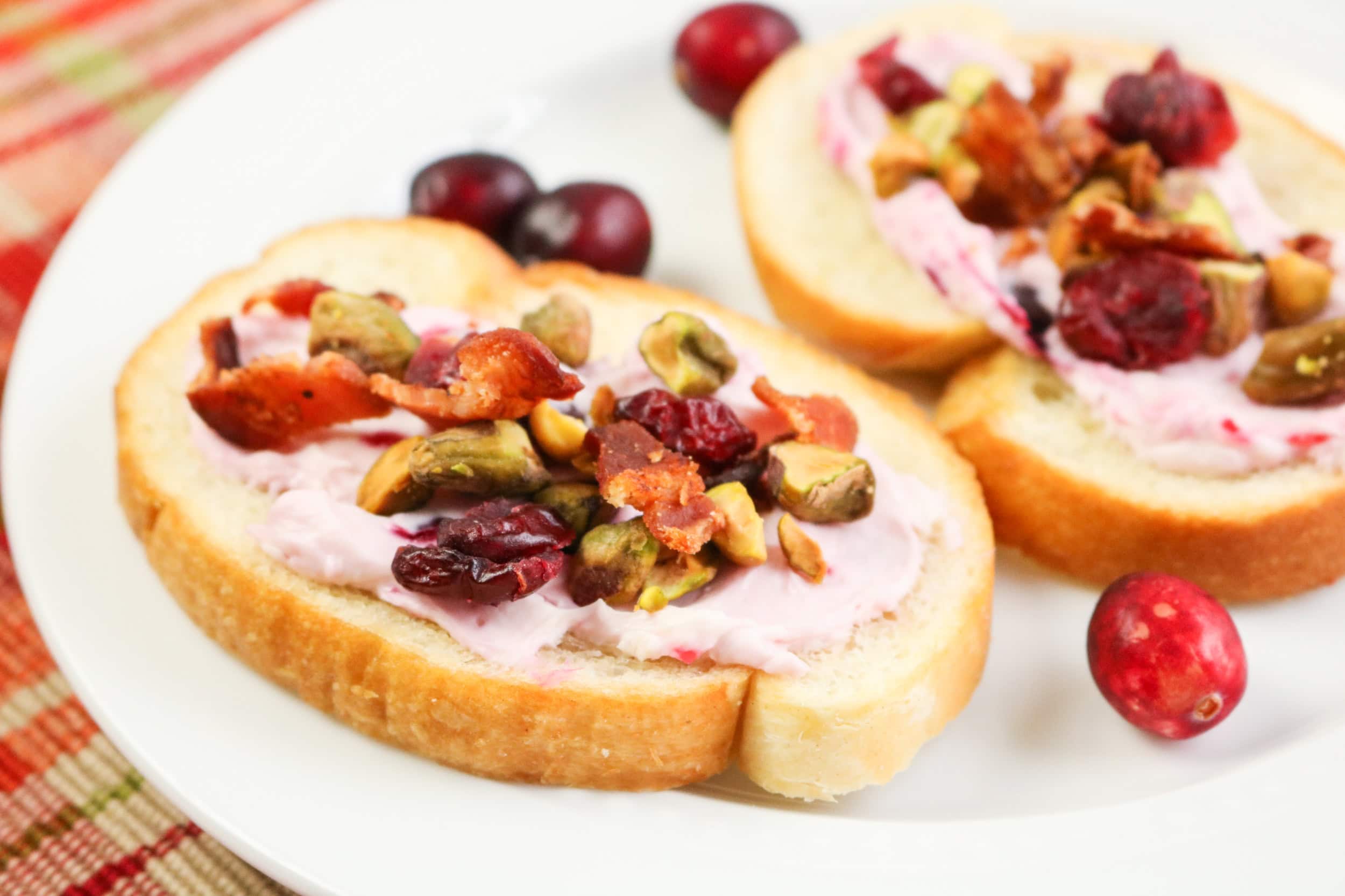 Bacon Pistachio and Cranberry Cream Cheese Crostini in a plate